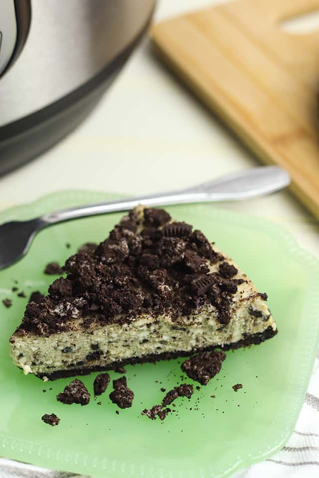 close-up pressure cooker oreo cheesecake on a green dessert plate with fork