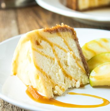 slice of cheesecake with caramel and apples on white plate