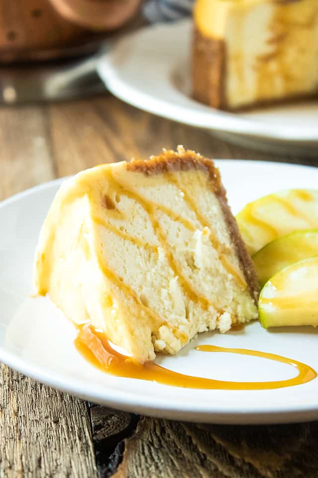 slice of cheesecake with caramel and apples on white plate