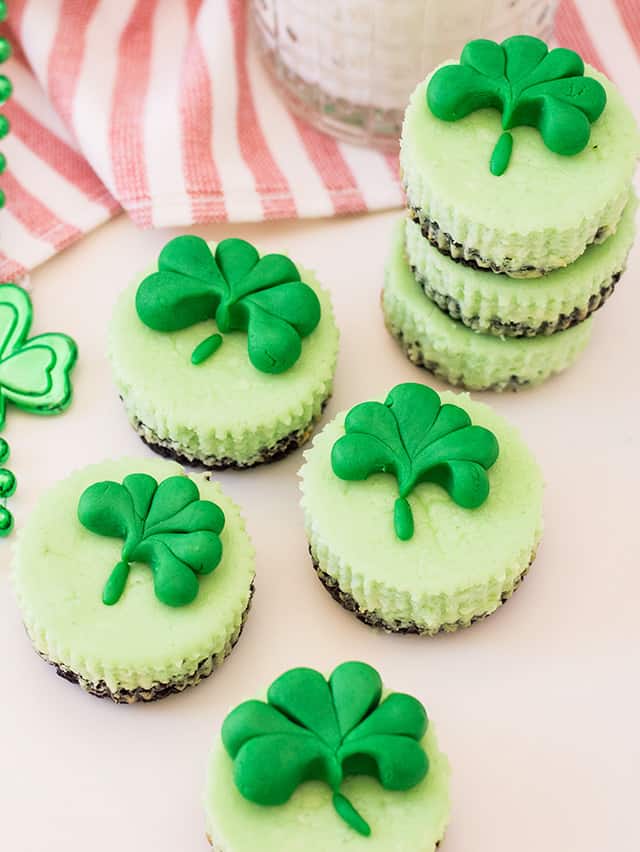 mini mint cheesecakes with fondant shamrocks on a striped linen