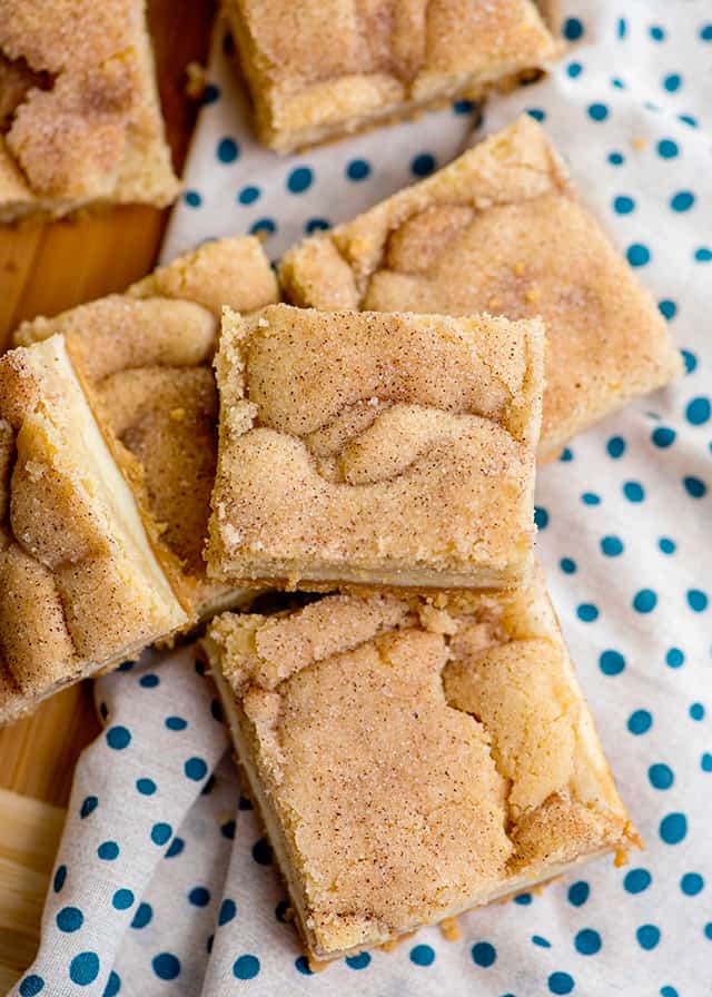 snickerdoodle cheesecake bars on white and blue fabric