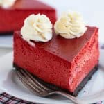 slice of red velvet cheesecake on a white plate with fork