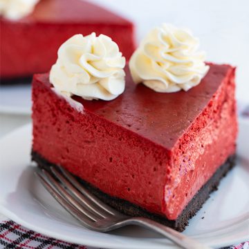 slice of red velvet cheesecake on a white plate with fork