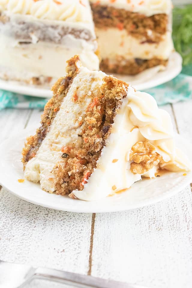 slice of carrot cake cheesecake cake on a white plate