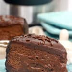 close up of chocolate cheesecake on a blue plate with other blue plates behind it