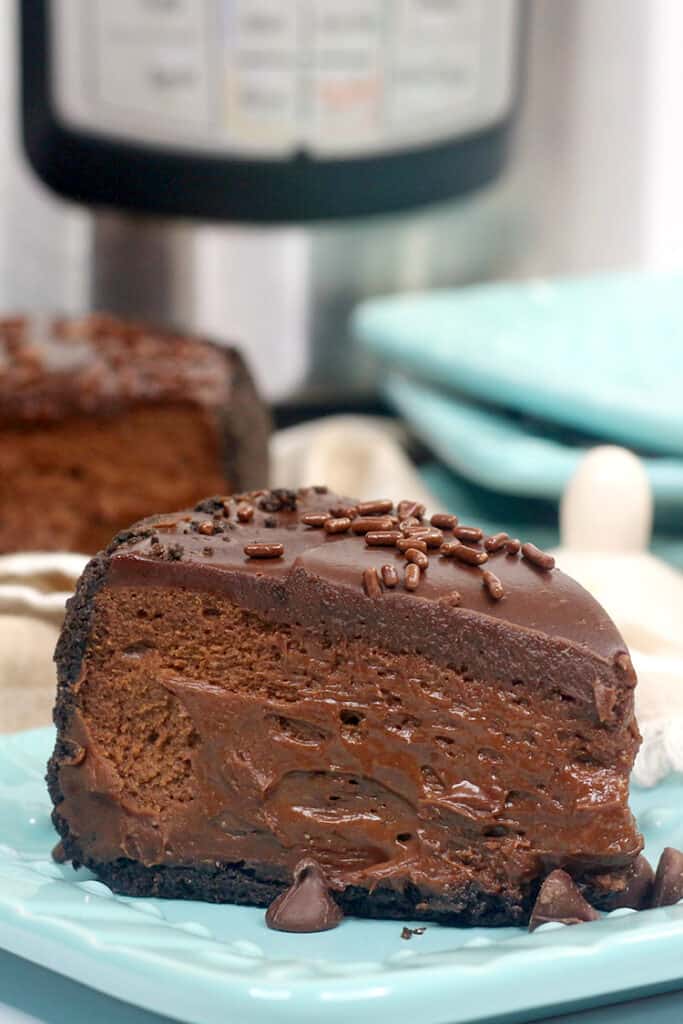 close up of chocolate cheesecake on a blue plate with other blue plates behind it