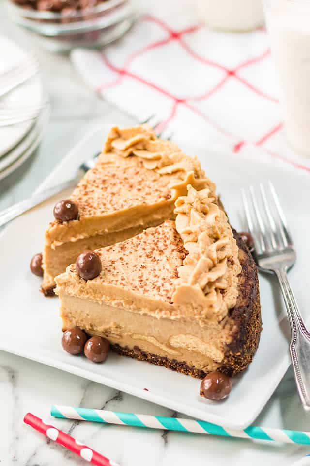 two slices of IP tiramisu inspired cheesecake on a white square plate with fork and straws beside it