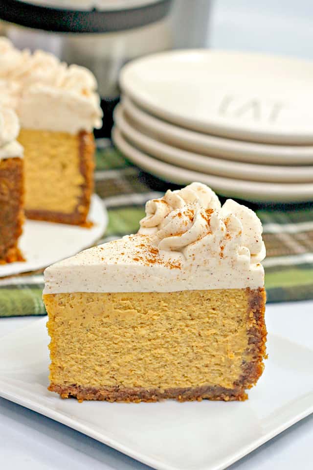 slice of pumpkin pie on a white square plate with green linen