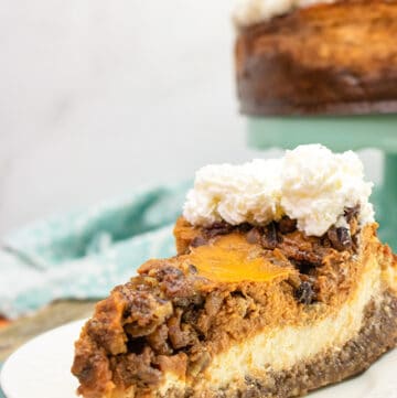 slice of pecan pie pumpkin cheesecake on a white plate with a blue charger