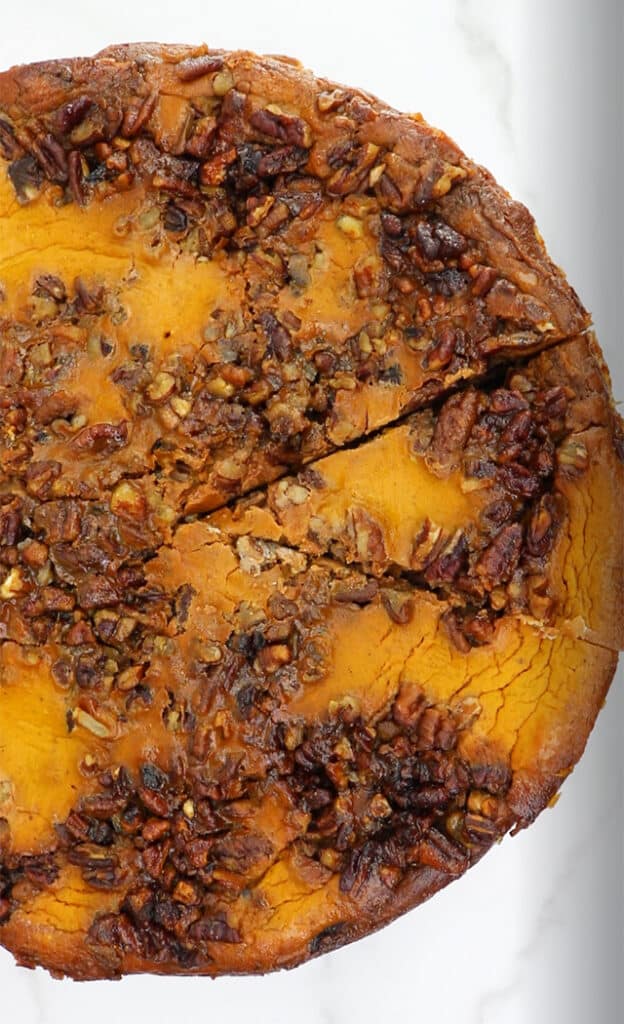 overhead photo of pecan pumpkin cheesecake pie with a slice cut