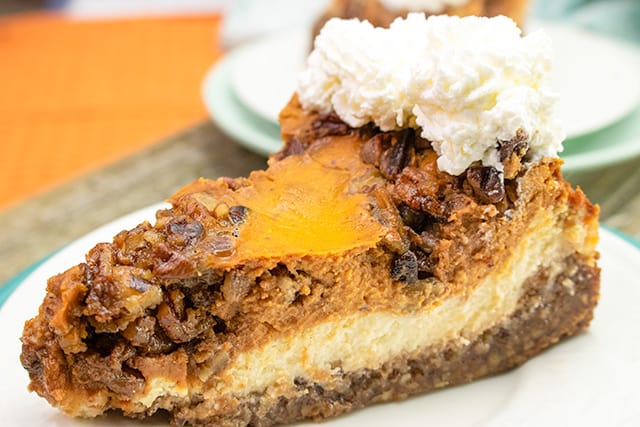 slice of cheesecake pie on a white plate with whipped cream on top