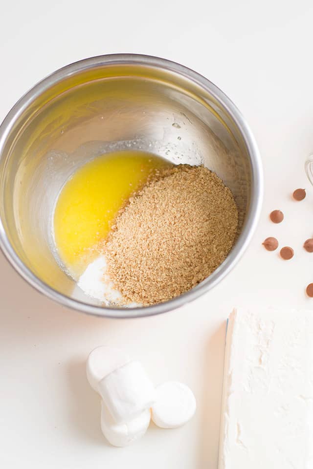 metal bowl full of ingredients to make the graham cracker crusts