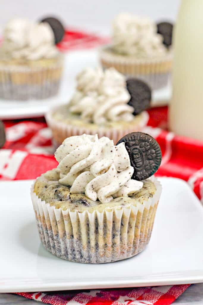 Mini oreo cheesecakes on a white plate with a red linen under the plate