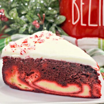 close up photo of cake on a white plate with a red cup behind it