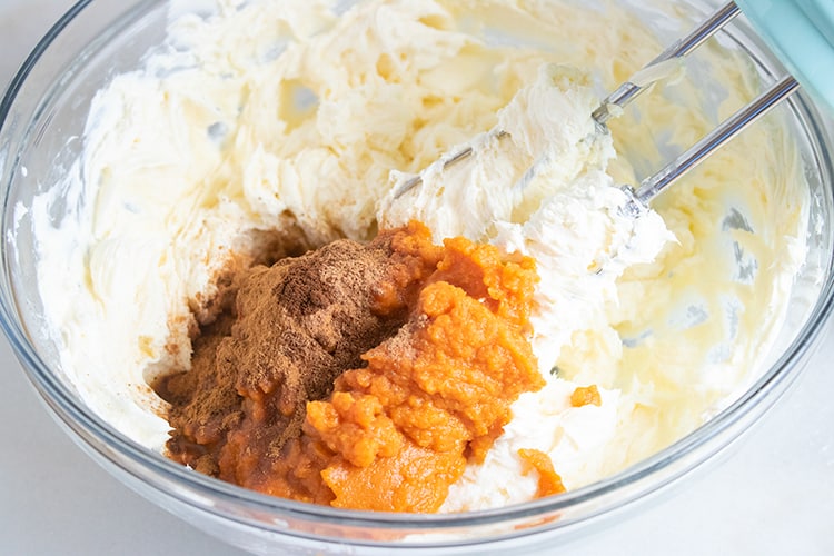 bowl of pumpkin cheesecake ingredients and a mixer