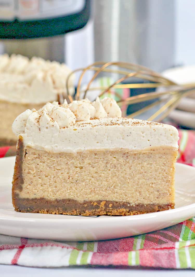 slice of eggnog cheesecake on a white plate with a red, white, and green fabric under it