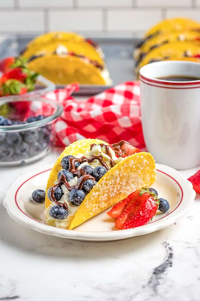 tacos on a white plate with a strawberry 