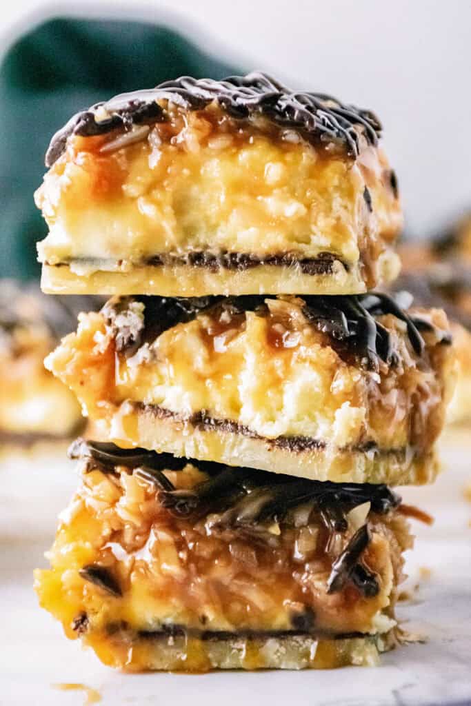  three samoa cheesecake bars stacked on a marble table